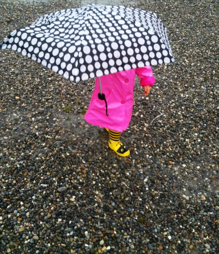 Glücksmoment Kind spielt im Regen